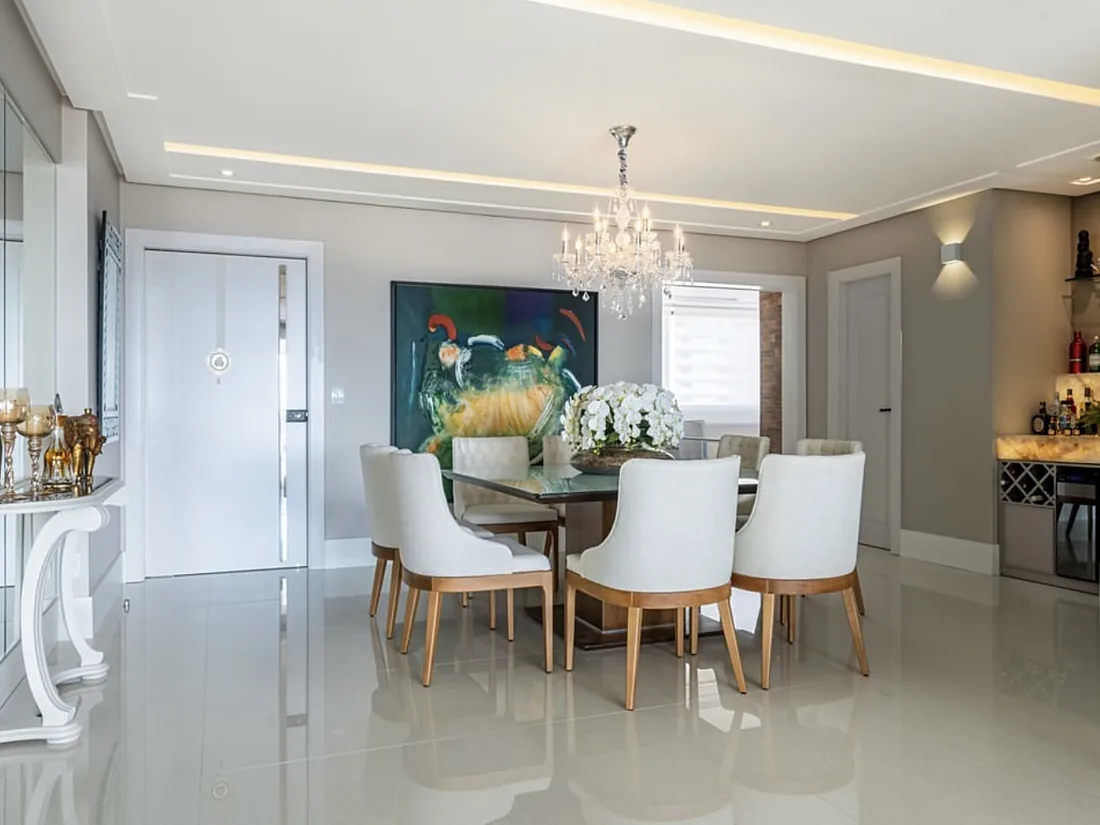 Sala de jantar com lustre de cristal e adega ao fundo