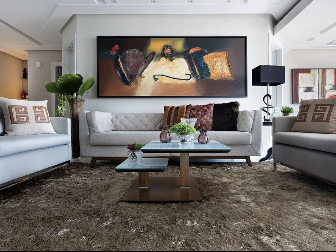 Living com sofás claros e obra de arte na parede